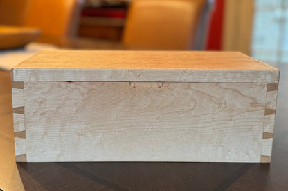 Wooden box on a reflective surface with a blurred background