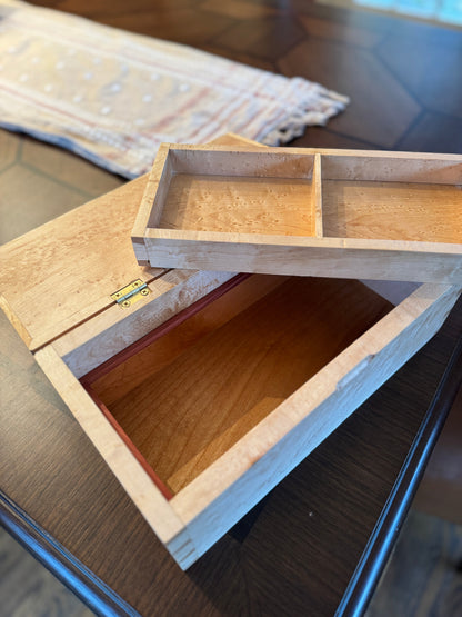 Wooden box with a divided interior on a reflective surface